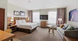 a hotel room with a bed and a couch at Best Western PLUS Hannaford Inn & Suites in Cincinnati +57 photos
