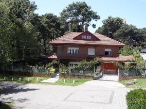 a house with a fence in front of it at Chalet familiar adosado Rosas Rojas in Villa Gesell