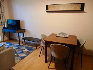 a dining room with a table and a desk with chairs at Apartament Na Wydmie - parter in Ustka