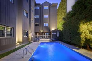 a swimming pool in front of a building at Hathor Hotels Mendoza in Mendoza