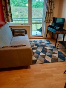 a living room with a couch and a piano at Apartament Na Wydmie - parter in Ustka