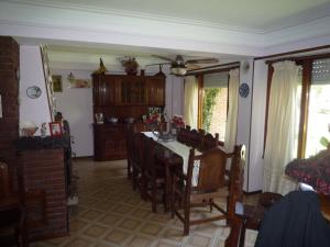 a dining room with a table and chairs at Chalet familiar adosado Rosas Rojas in Villa Gesell