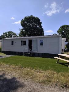 a large white trailer with a picnic table in front of it at Wima Chalet in Sevenum