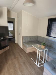 a living room with a couch and a table at Wima Chalet in Sevenum