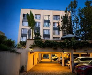 a building with cars parked in a parking lot at Ongata Rongai Pool Studio Near Nairobi National Park and giraffe center in Ongata Rongai 