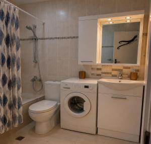 a bathroom with a toilet and a washing machine and a sink at KRAKEN Apartment in Leptokarya +31 photos