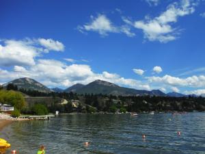 a woman standing on the shore of a lake at The Beach Point - Ground Floor BBQ in Invermere