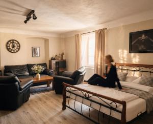 a woman sitting on a bed in a living room at Frauenberg Villa in Banská Štiavnica