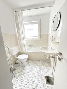 a white bathroom with a toilet and a sink at FeWo Reimer in Horn-Bad Meinberg