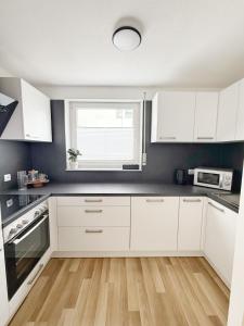 a kitchen with white cabinets and a window at FeWo Reimer in Horn-Bad Meinberg