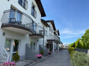 a white building with balconies and flowers on the street at Villa Rowena in Rowy