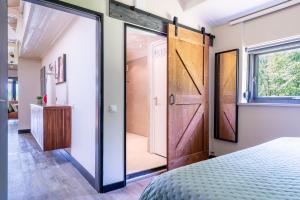 a sliding door in a bedroom with a bed at Chalet Achterbosch in Lieshout
