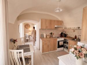 a kitchen with a woman walking into a room at Frauenberg Villa in Banská Štiavnica