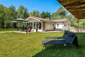a yard with a chair and a table and a house at Chalet Achterbosch in Lieshout