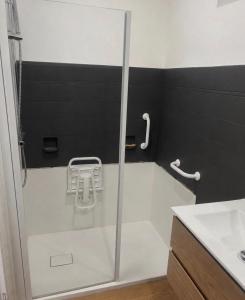 a shower with a glass door in a bathroom at Le Nid de la Distillerie in Hérépian