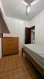 a bedroom with a bed and a dresser at Casa temporada Ilha Comprida 350m da praia in Ilha Comprida
