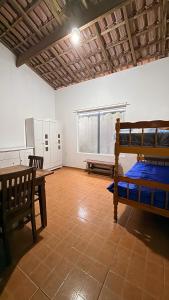 a room with a bunk bed and a table at Casa temporada Ilha Comprida 350m da praia in Ilha Comprida +11 photos