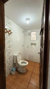 a bathroom with a toilet in a room at Casa temporada Ilha Comprida 350m da praia in Ilha Comprida