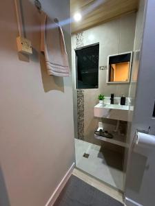 a bathroom with a sink and a mirror at Studio Aconchegante - com Garagem Privativa e Ar Condicionado REV391 in Joinville +27 photos