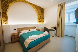 a bedroom with a bed with two towels on it at B&B Hipponion in Vibo Valentia