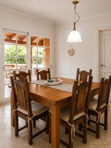 a dining room with a wooden table and chairs at Caelum House Familiar Con Cochera in Rafaela
