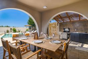 a dining room with a table and chairs and a kitchen at Villa Kalymnos by Villa Plus in Kolymbia