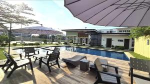 a patio with chairs and tables and an umbrella at Primerose Manor - Near Mactan Airport & Beaches in Pajak
