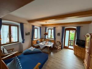 a living room with a blue bed and a table at Ferienhaus Spornitz in Mittenwald