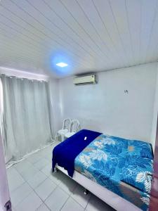 a bedroom with a bed with a blue blanket on it at Casa Barreirinhas in Barreirinhas