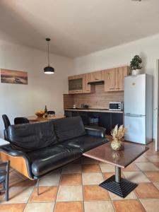 a living room with a black leather couch and a kitchen at Apartment Vužar in Opatija