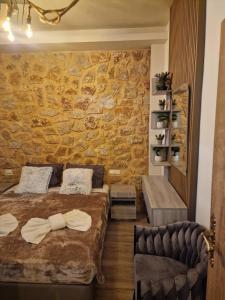 a bedroom with a bed and a stone wall at Errik Luxury House in Faliraki