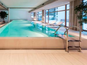 Hotel Cristallo في سولدا: مسبح في غرفة في الفندق مع حوض سباحة