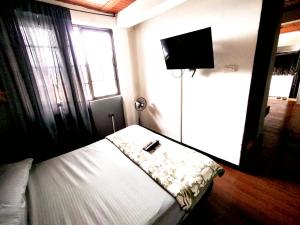 a bedroom with a bed and a flat screen tv at Apartaestudio confortable 1 en Combia in Pereira