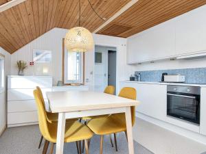 a kitchen with a white table and yellow chairs at 4 person holiday home in Lemvig in Lemvig