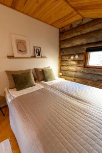 a bed in a room with a wooden wall at Voimakelo - renovated - near ski bus in Kuusamo