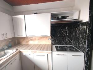 a kitchen with white cabinets and a stove top oven at Apartaestudio confortable 1 en Combia in Pereira