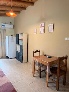 a kitchen with a table and chairs and a refrigerator at Cabañas Las Marias in San Luis