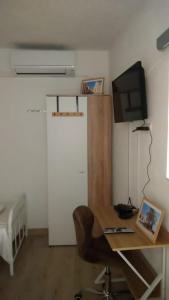 a room with a desk with a computer and a television at Studio apartman Marija 2 in Bol