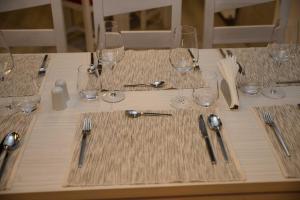 a table with wine glasses and silverware on it at Net Hotel Pitesti in Piteşti