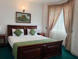 a bedroom with a large bed and a window at The Rock Hotel in Nuwara Eliya