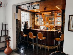 a bar with chairs and a counter in a room at The Rock Hotel in Nuwara Eliya