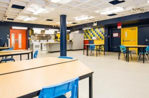 a cafeteria with tables and blue chairs in a room at Résidences du Cégep de Rimouski in Rimouski