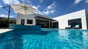 a house with a swimming pool with an umbrella at Casa Aqua in Nilo