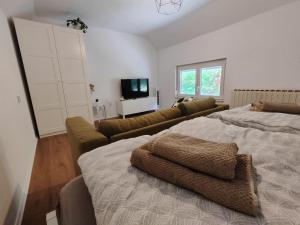 a living room with a bed and a couch at Holiday Home Mila in Spodnja Idrija