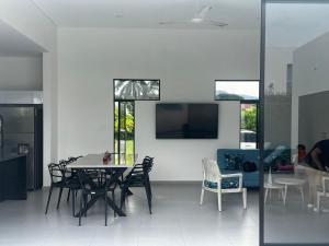 a dining room with a table and chairs and a tv at Casa Aqua in Nilo