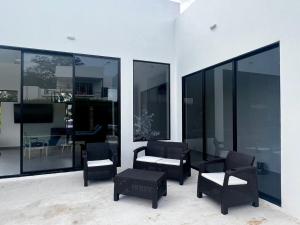 a living room with chairs and tables and windows at Casa Aqua in Nilo