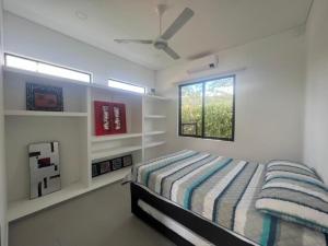 a white bedroom with a bed and a window at Casa Aqua in Nilo +23 photos