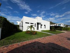 a white house with a palm tree and a brick driveway at Casa Aqua in Nilo