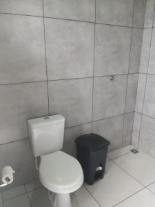 a bathroom with a toilet and a trash can at Espaço Manacá in Dourados