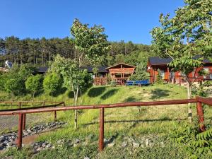 a log home with a fence in front of it at La Hacienda in Cheţani